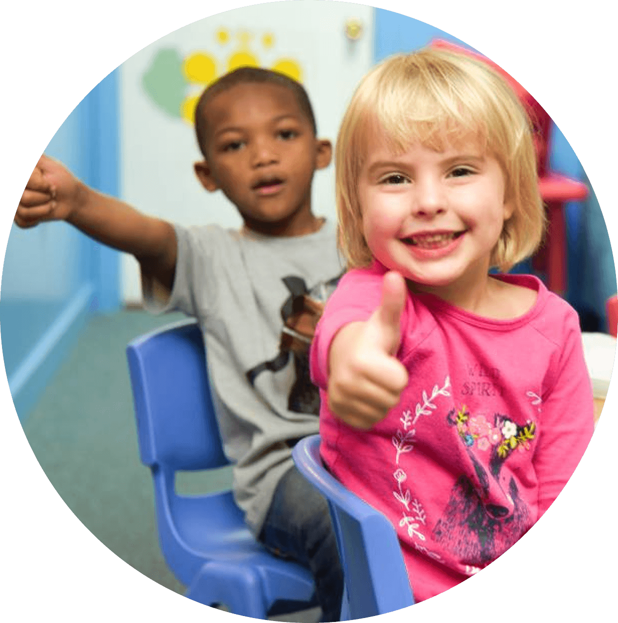 Two smiling children giving a joyful thumbs up